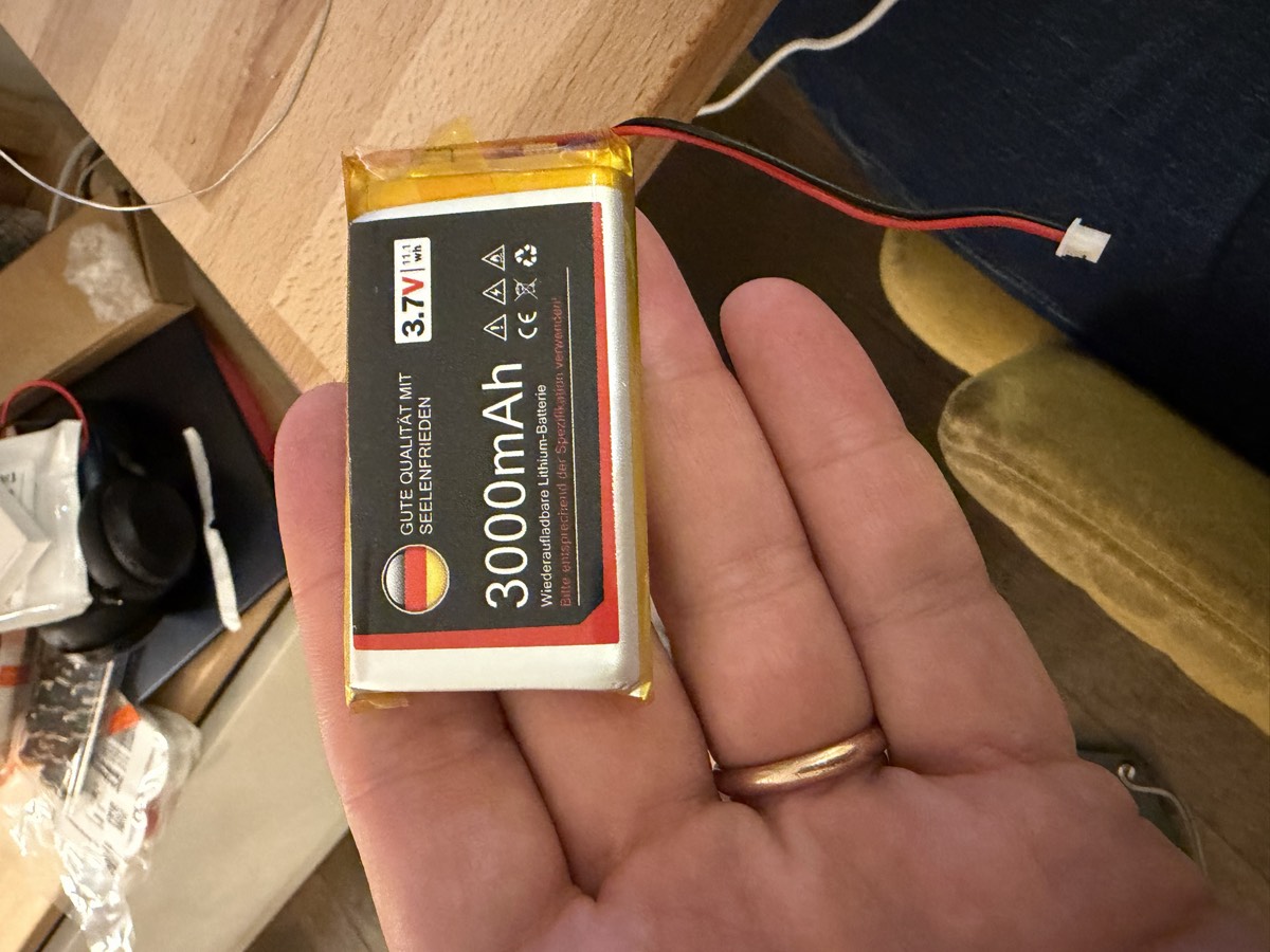 Une batterie lithium plate de 3000 mAh tenue dans une main.