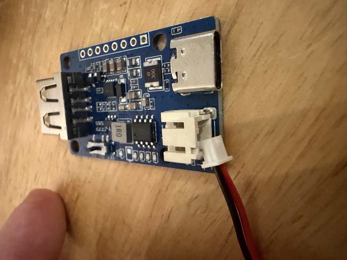 Une petite carte de charge bleue avec une prise USB-C et un connecteur blanc.