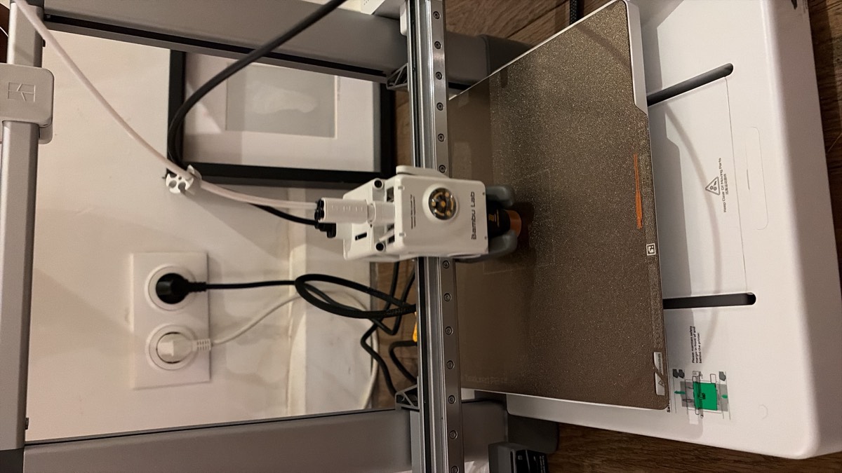 La buse d'une imprimante 3D en train de déposer du plastique fondu sur le plateau.