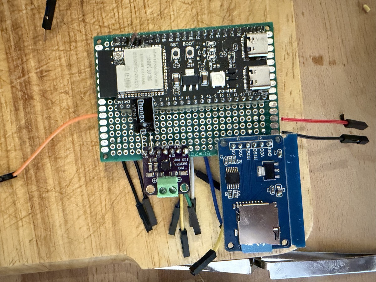 Une plaque à pastilles verte sur laquelle sont soudés un ESP32 et plusieurs petits modules.